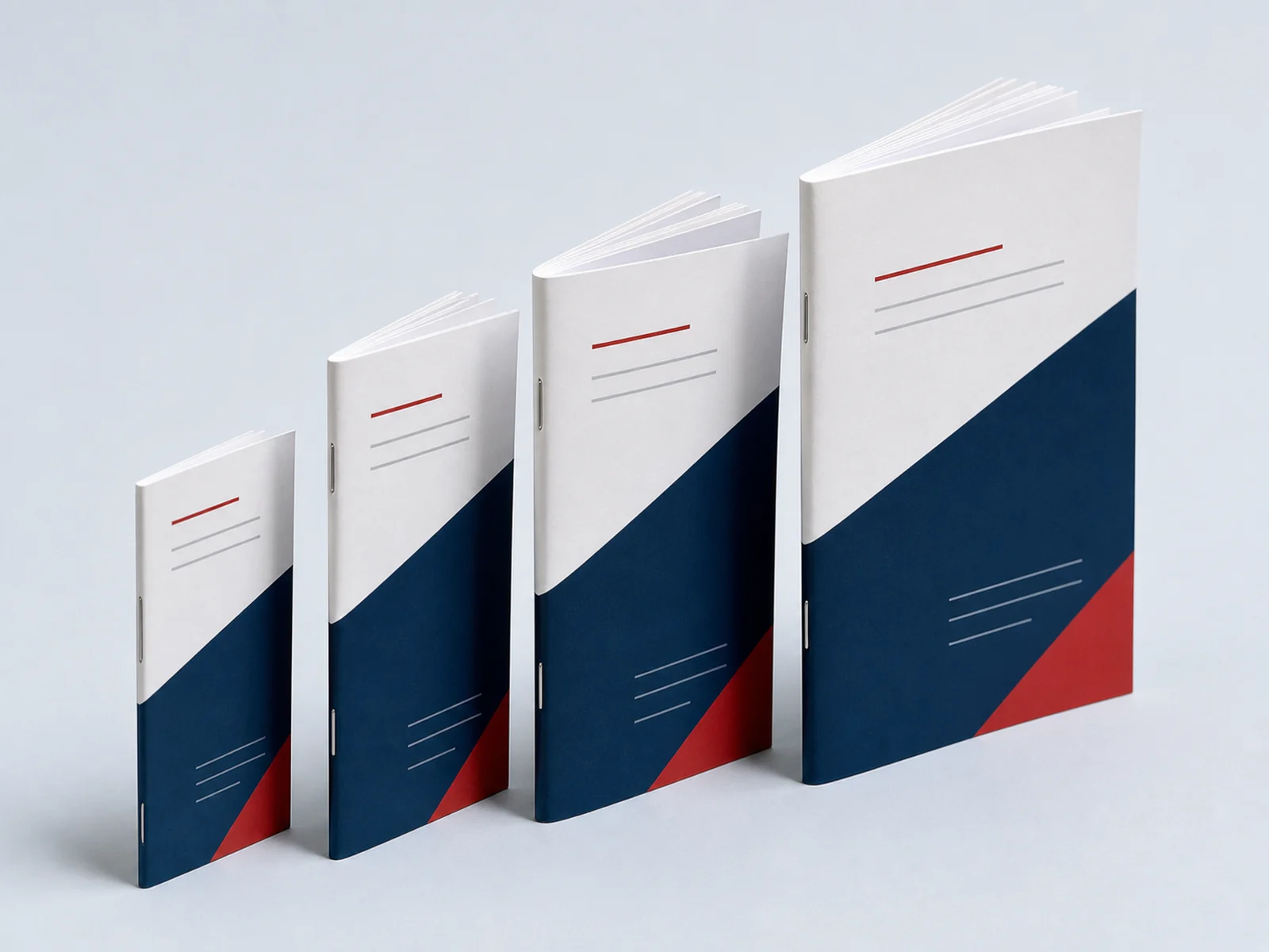 Four saddle stitched booklets of increasing thickness standing in a row