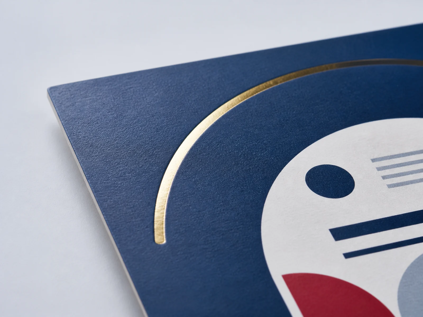 Gold foil catching raking light on a printed card front