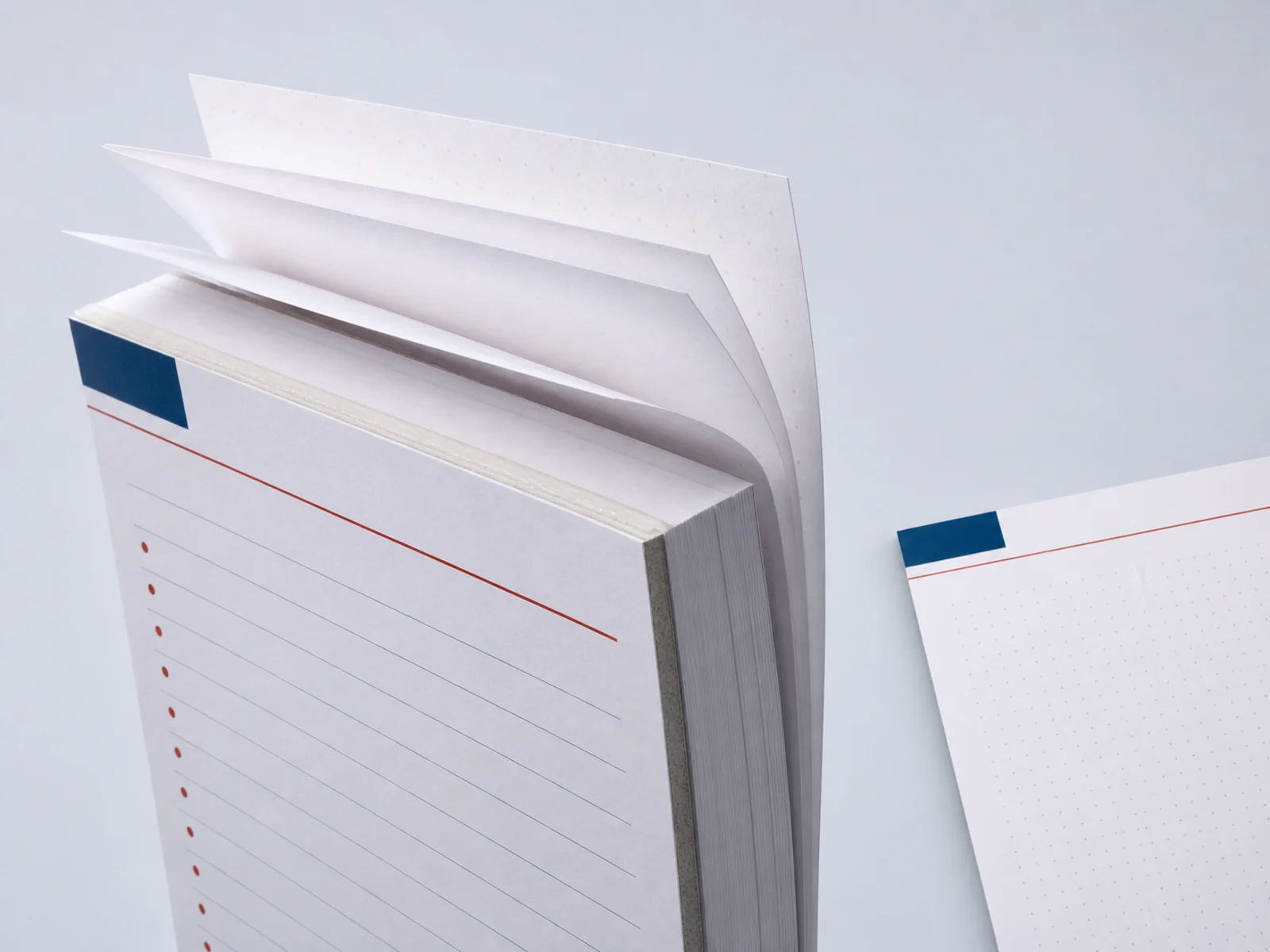A close view of a notepad's padded glue edge and chipboard backing