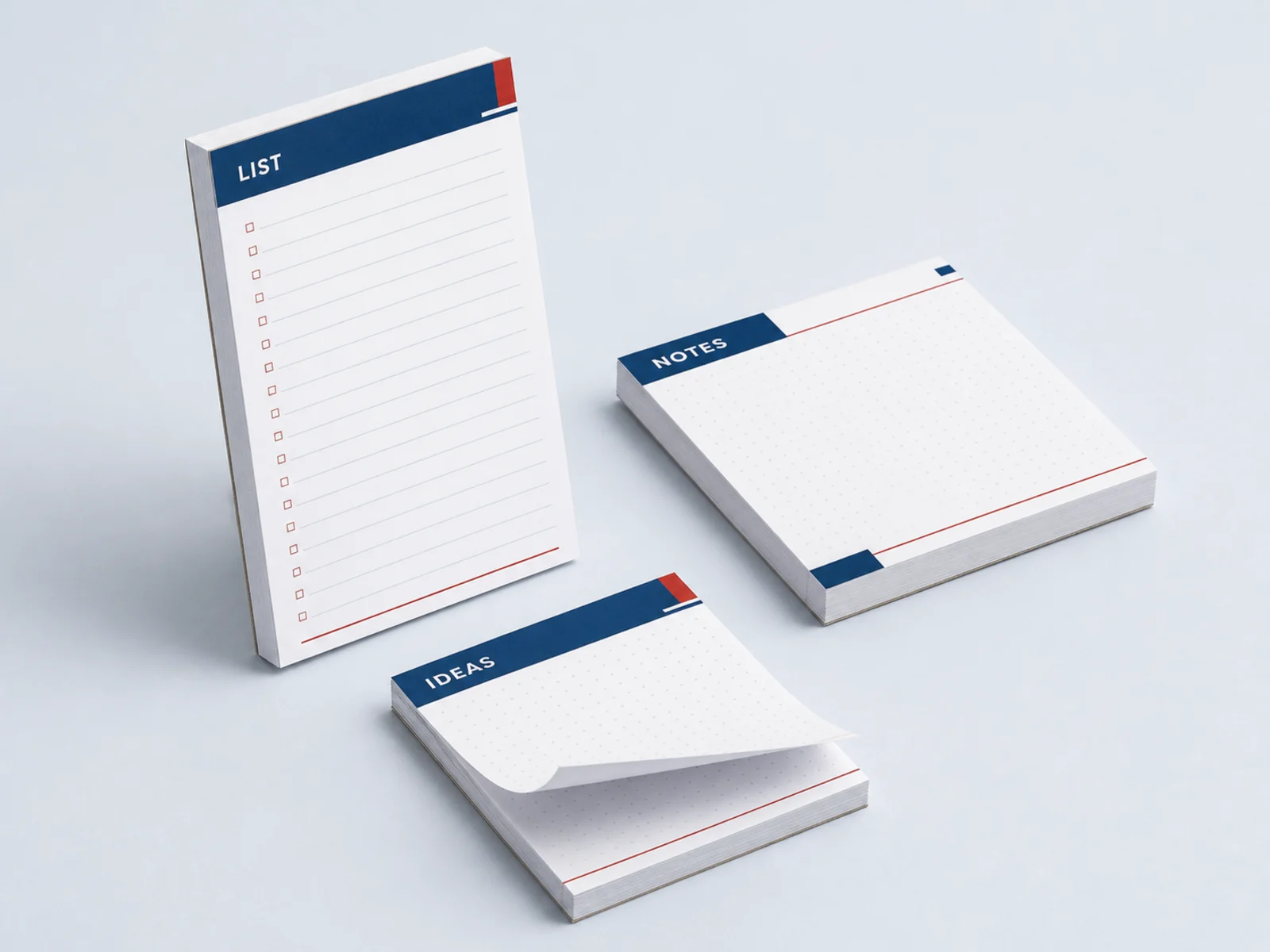 Three notepads of different sizes stacked with the top sheet half torn off